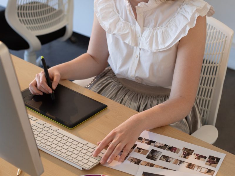 young-caucasian-female-graphic-designer-working-on-graphics-tablet-and-computer-at-desk.jpg